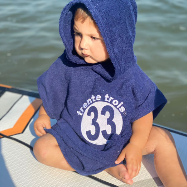 Un poncho marine pour bébé, estampillé "trente-trois" de la marque régionale 33.