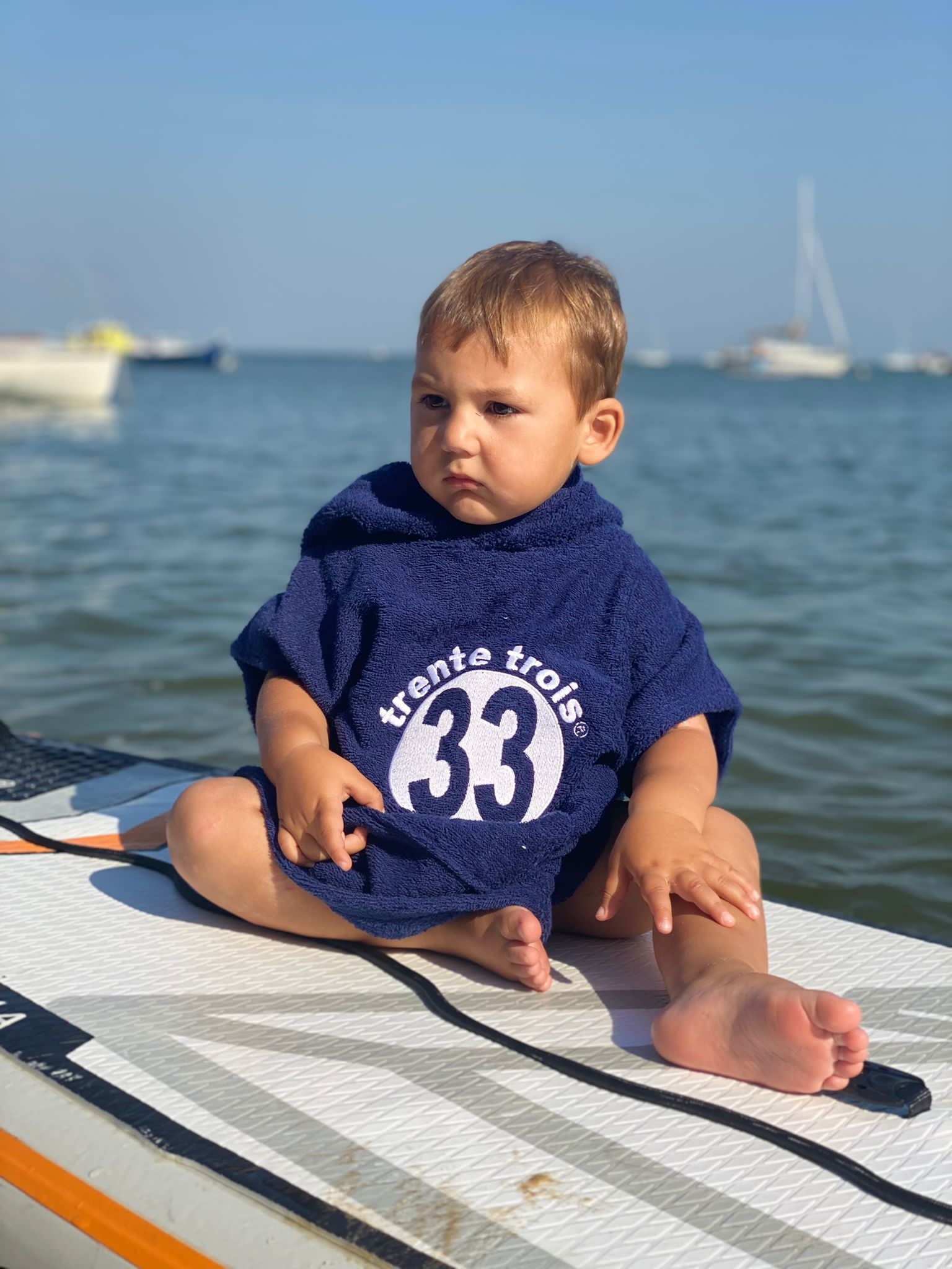 Un poncho marine pour bébé, estampillé "trente-trois" de la marque régionale 33.