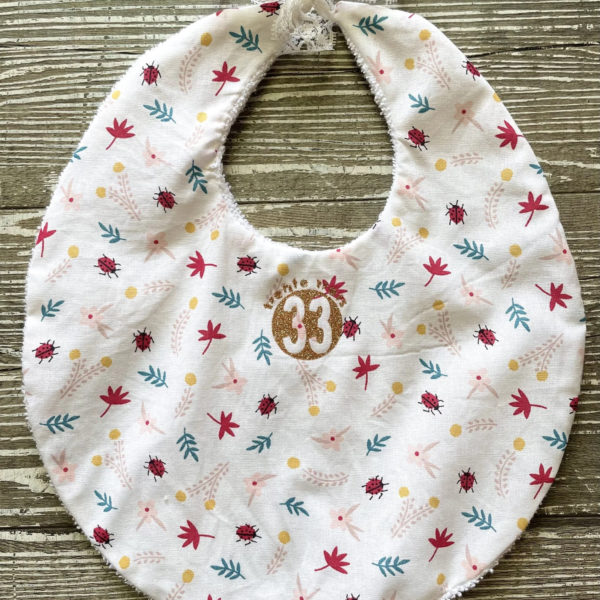 Un bavoir coccinelle de la marque régionale 33.