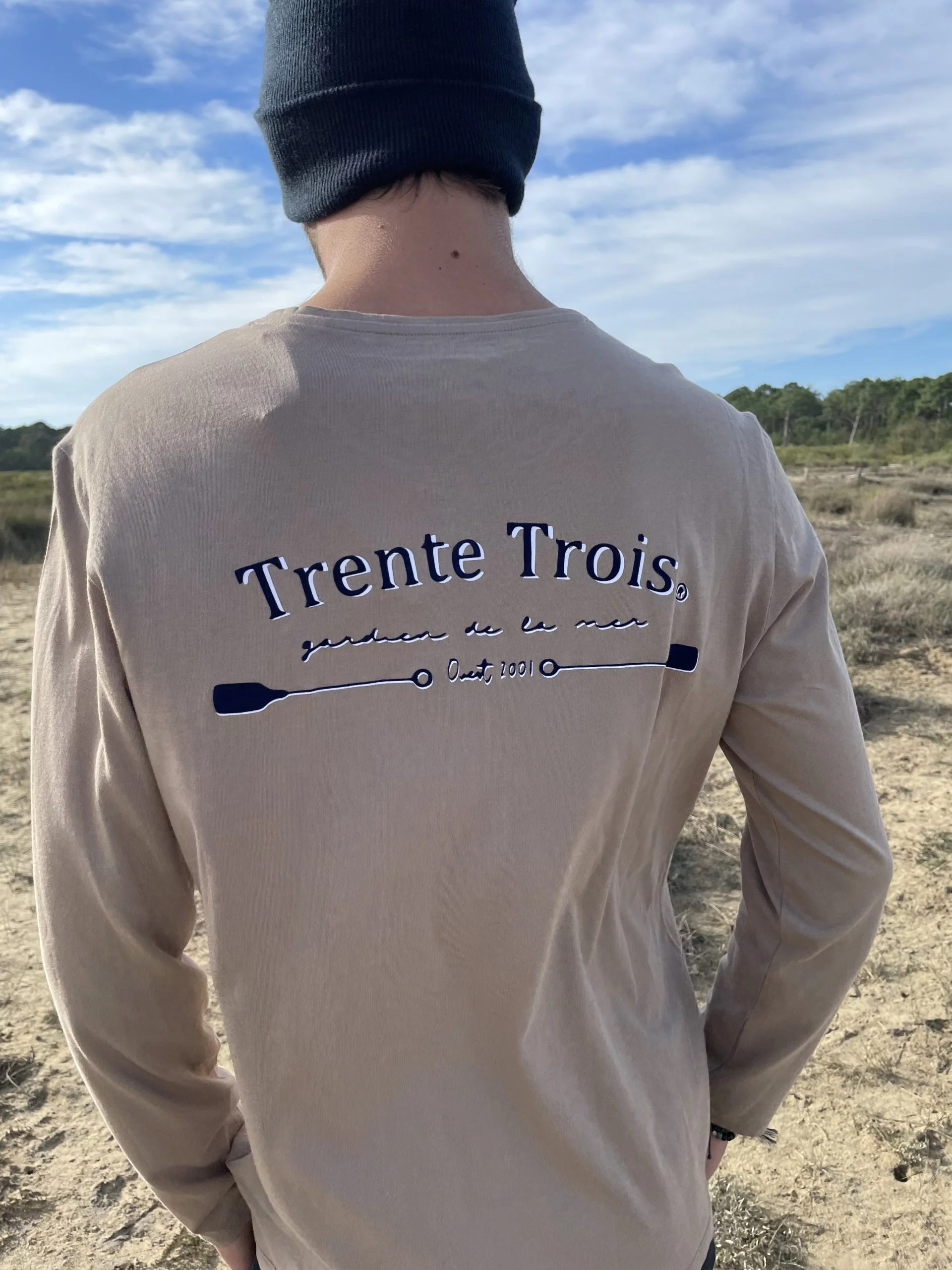 Un tee-shirt beige à manches longues pour homme, estampillé "trente-trois" de la marque régionale 33.