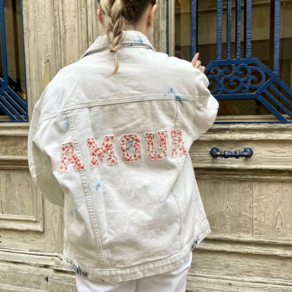 Une veste en jean pour femme, estampillée "Amour" de la marque régionale 33.