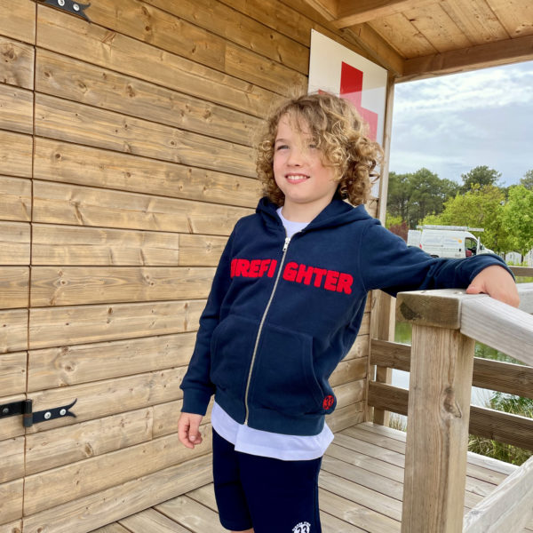 Une veste zippée marine pour garçon, estampillée "Fire Fighter" de la marque régionale 33.