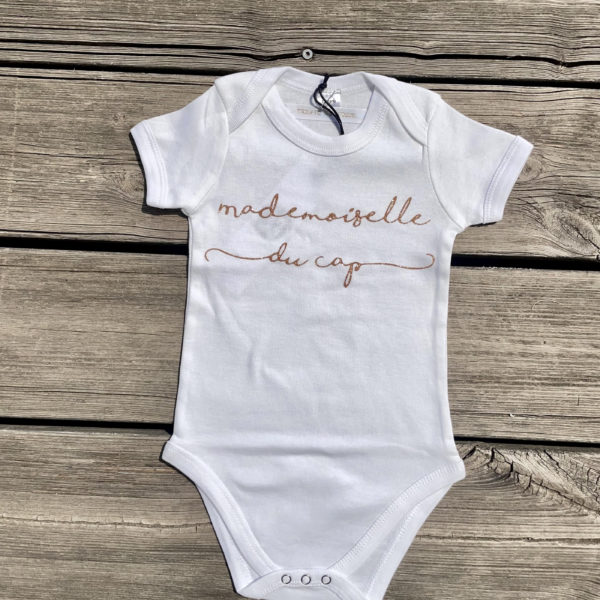 Un body pour bébé, estampillé "Mademoiselle du cap" de la marque régionale 33.