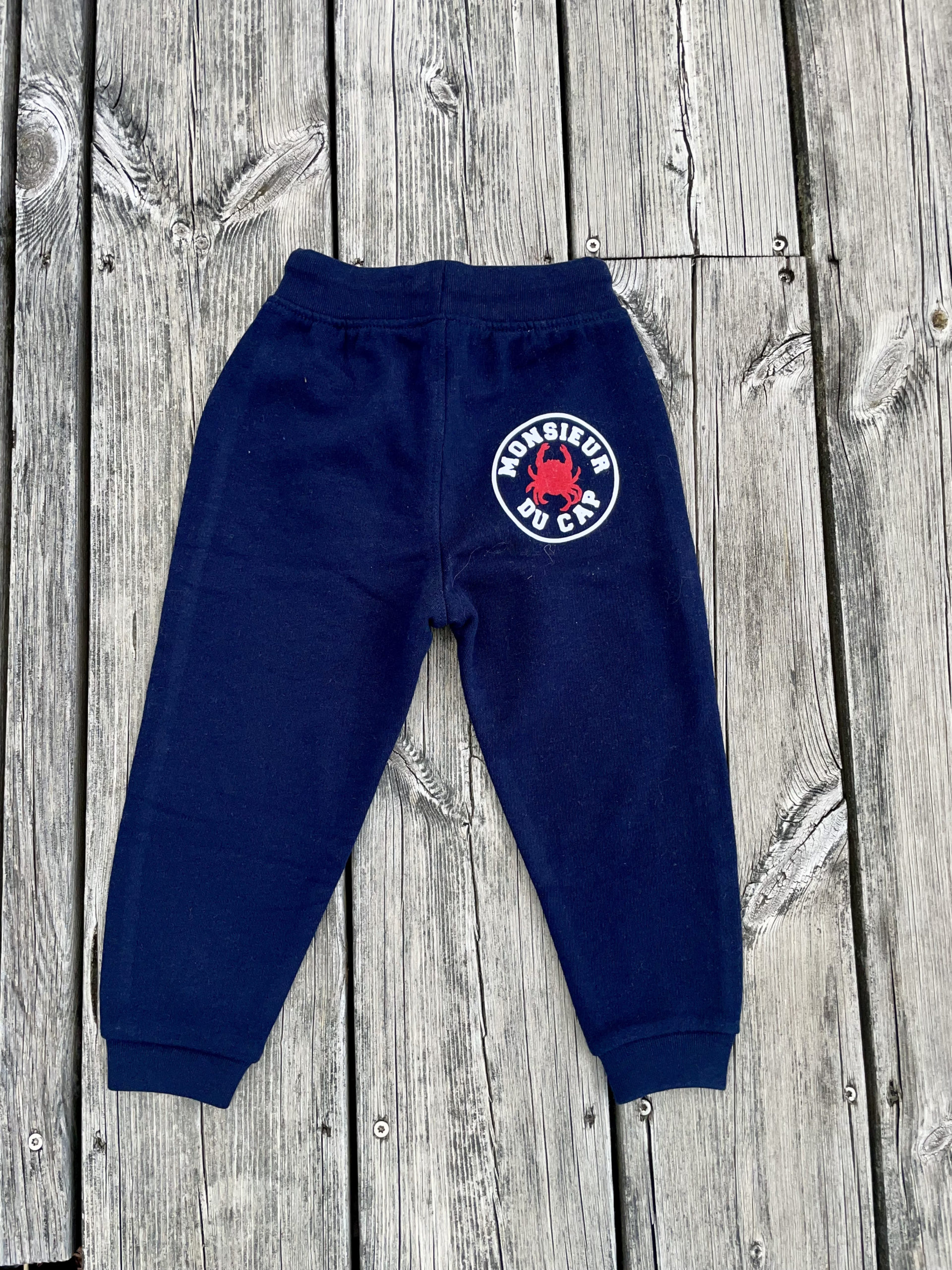 Un jogging marine pour bébé, estampillé "Monsieur du Cap" de la marque régionale 33.