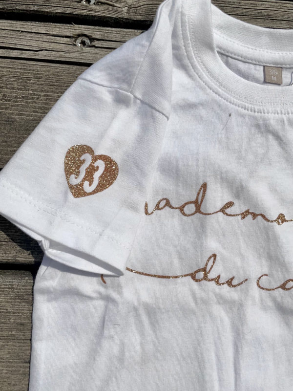 Un tee-shirt blanc pour bébé, estampillé "Mademoiselle du cap" de la marque régionale 33.