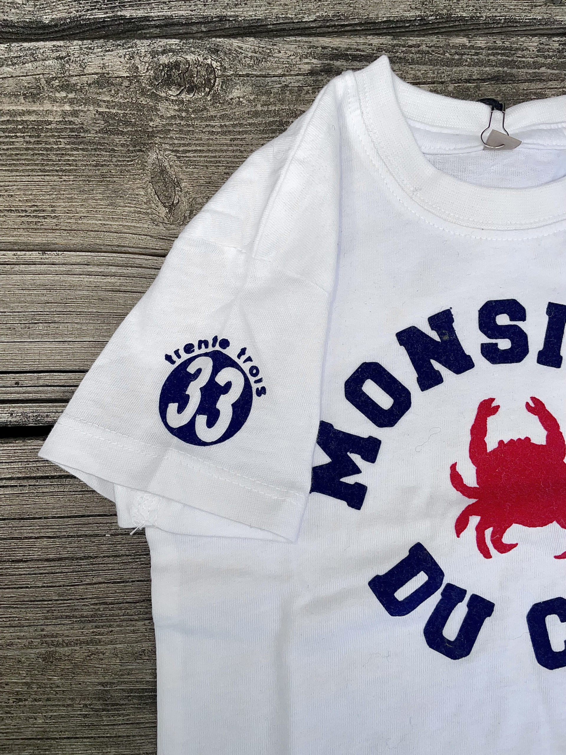 Un tee-shirt blanc pour bébé, estampillé "Monsieur du Cap" de la marque régionale 33.